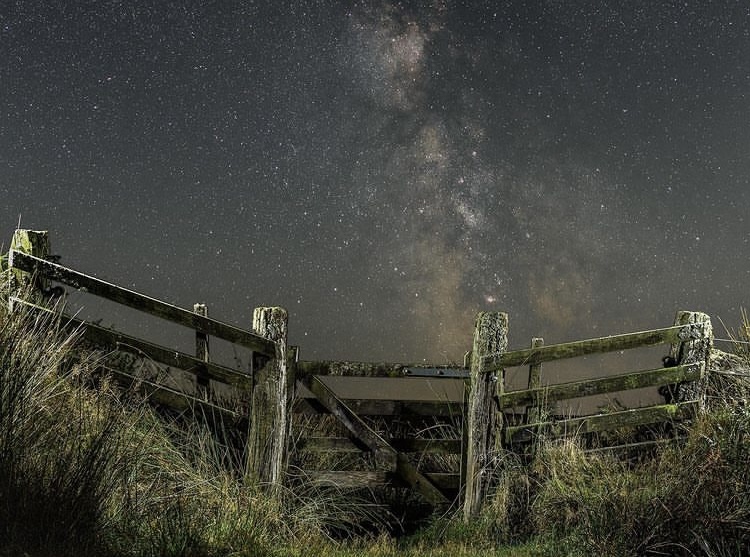 Wooden gate in fence with Exmoor starry skies behind with spooky Halloween vibes