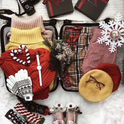 Winter packing laid out on suitcase