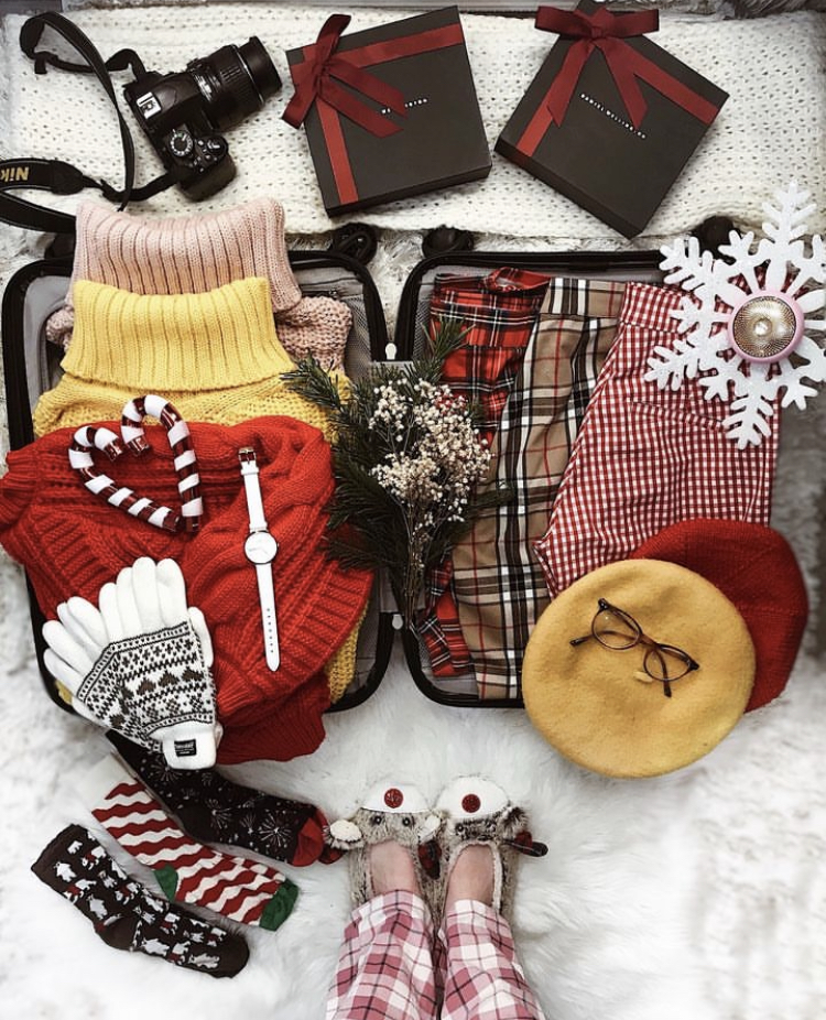 Winter packing laid out on suitcase