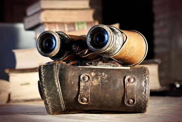 Vintage binoculars on leather case with books