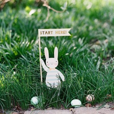 Paper bunny holding "start here" flag with small Easter eggs in the grass surrounding it - easter egg hunt on Exmoor idea