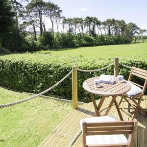 The Pines, Cleeve Park - deck with outdoor furniture overlooking the fields & trees of Exmoor